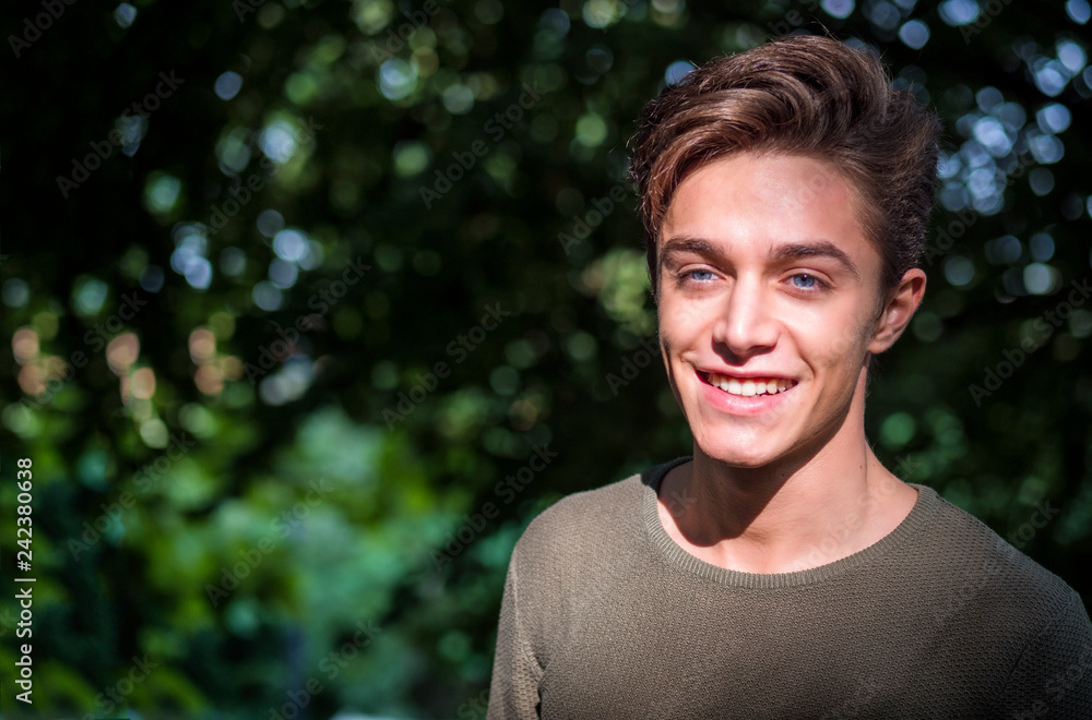 One handsome blue eyed young man in urban setting in European city park One handsome blue eyed young man in urban setting in European city park
