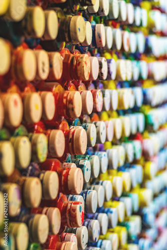 many cans of paint with lids lined in a row © vadimalekcandr