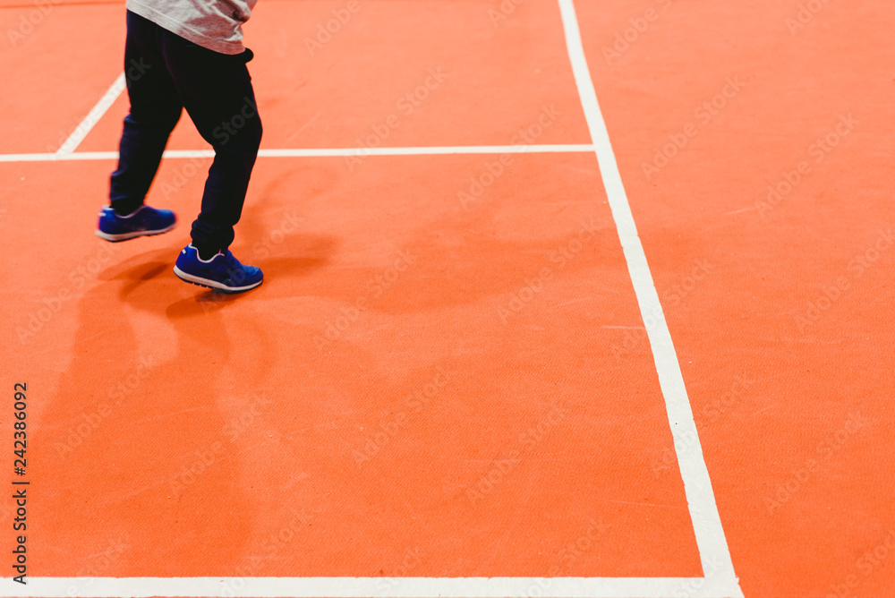 Obraz premium Child playing tennis near the white lines of the court.