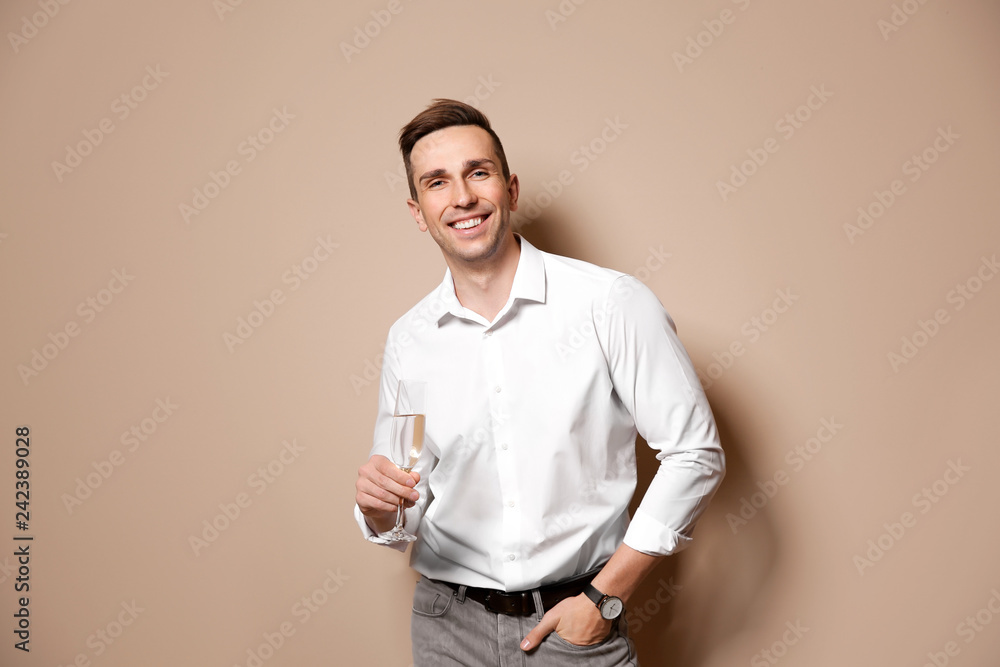 Handsome man with glass of champagne on color background Handsome man with glass of champagne on color background