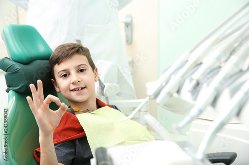 Happy little boy having dentist's appointment in modern clinic