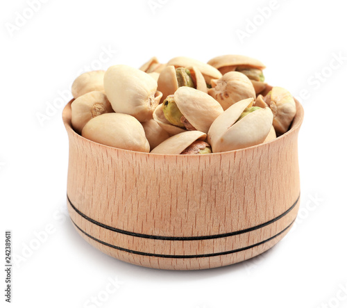 Organic pistachio nuts in wooden bowl isolated on white, closeup