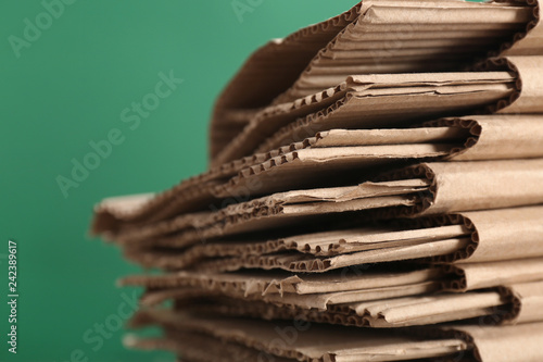 Cardboard pile on color background, space for text. Waste recycling concept