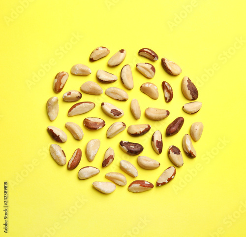 Flat lay composition with Brazil nuts on color background