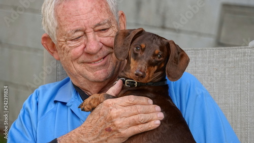 Fototapeta Naklejka Na Ścianę i Meble -  Happy, smiling senior man holding his dog