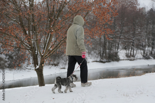 the man walking with a dog in cloudy winter day