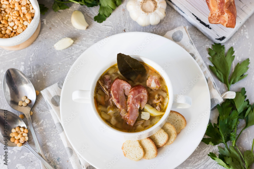 Thick pea soup with smoked meats in a white plate Thick pea soup with smoked meats in a white plate