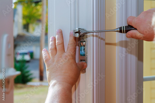 Closeup of a professional locksmith installing or repairing a new deadbolt lock