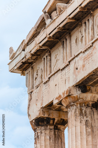 Marble horses heads sticking out from the famous Parthenon temple facade on Acropolis hill in Athens, Greece photo