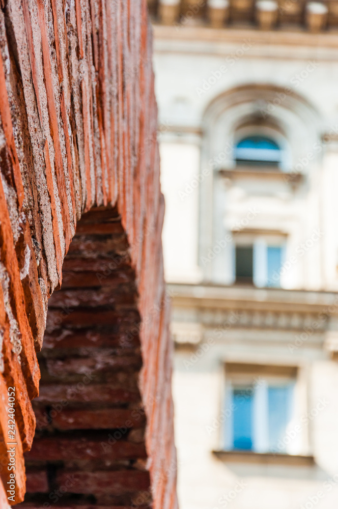 The remains of the Roman empire civilization. Roman red brick arch close-up with classical facade of residential building in Sofia