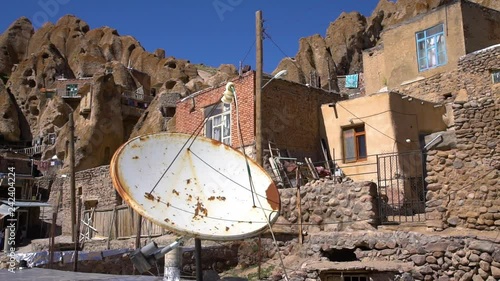 Handheld, wide, panning, exterior, daytime shot of the Kandovan Village of Rock Houses.