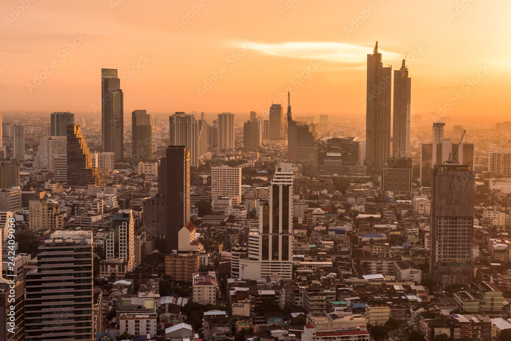 Aerial view of modern office and condominium building in Bangkok with orange sunset.