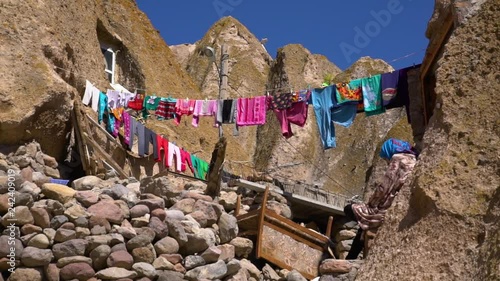 Steady, wide shot of clothes hanging on clothesline in the rocky Kandovan Village. 