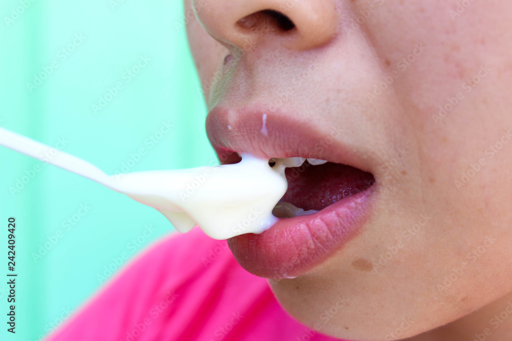 Naklejka premium Close up mouth of Asian young woman eating yogurt for diet in lunch.
