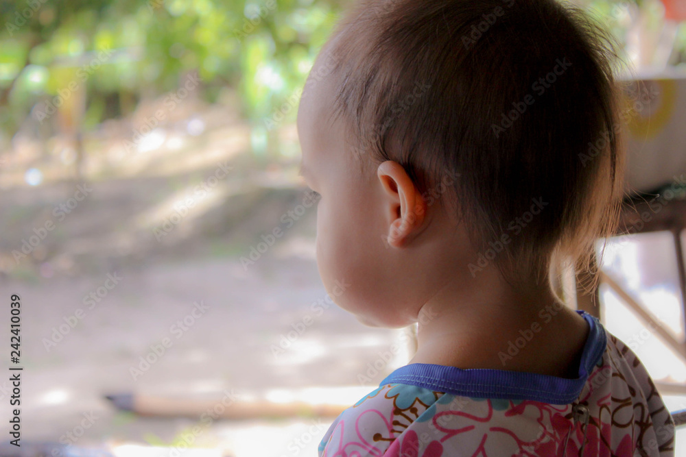Back view of Asian little child girl standing on ground in backyard. Back view of Asian little child girl standing on ground in backyard.