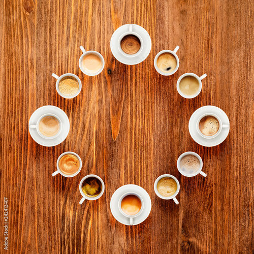 Some cups of coffee on wooden table, top view. Coffee brake concept.