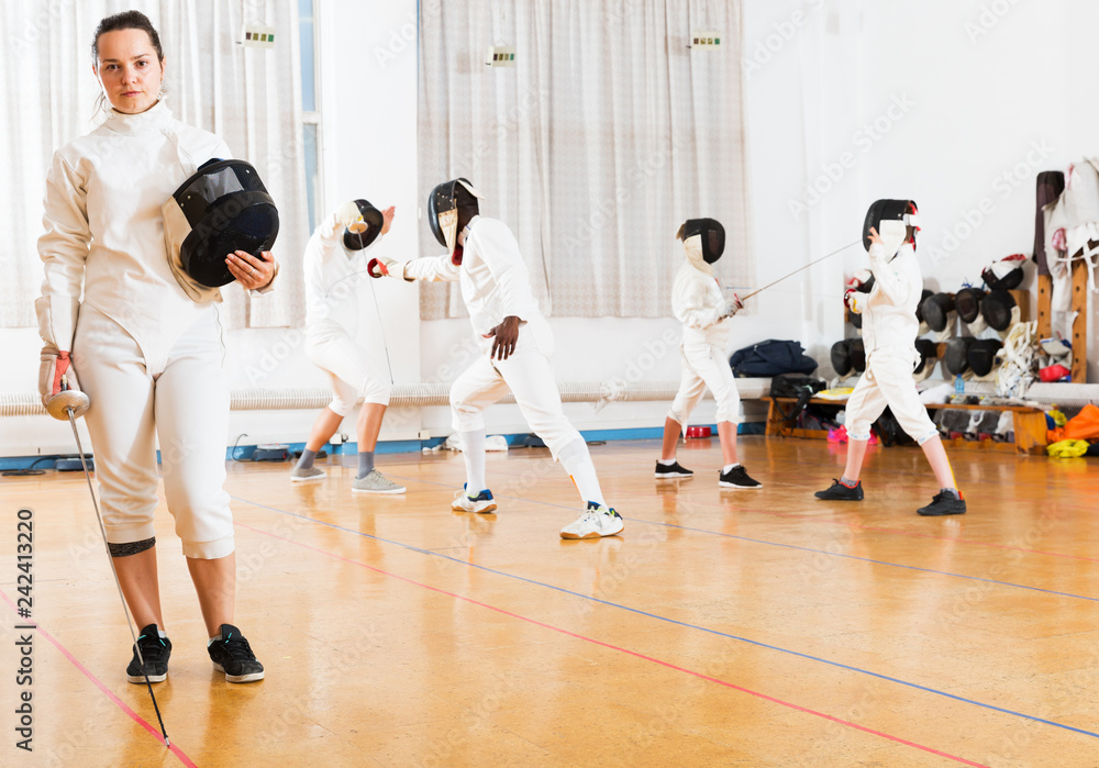 Obraz premium Woman in fencing uniform in gym