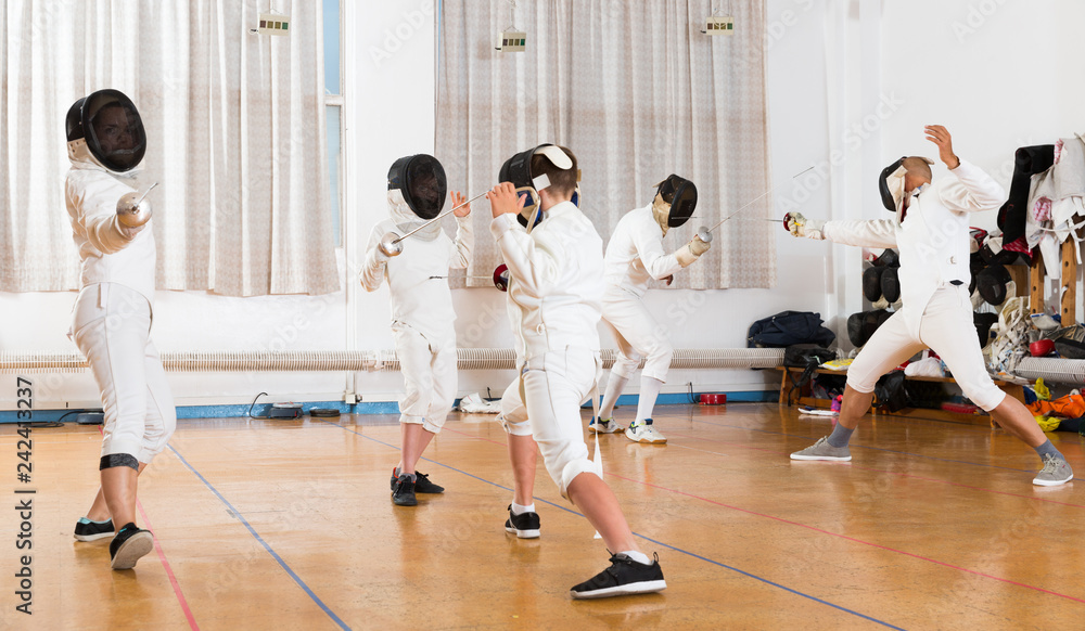 Mixed age group of athletes at fencing exercise