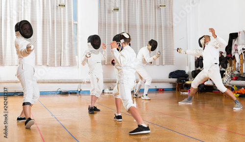 Mixed age group of athletes at fencing exercise