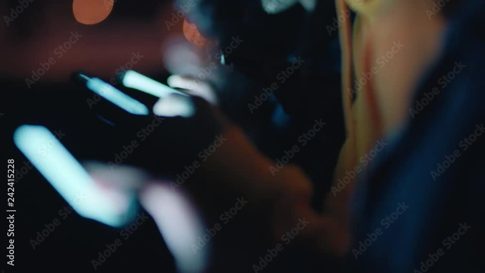 close up group of friends using smartphone mobile technology hanging out on rooftop at night enjoying weekend sharing social media messages addiction concept