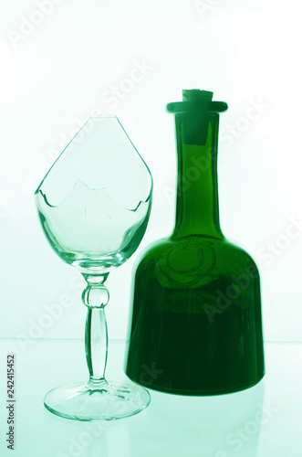 Bottle of wine and a broken glass on a light background