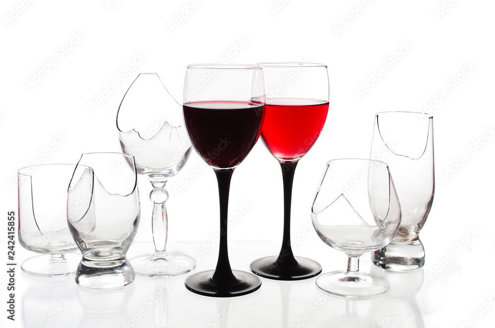 Two glasses of red wine on the background of broken glasses on a light background