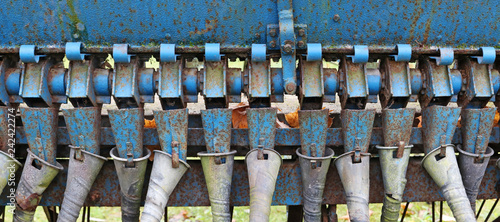 Rusty tubes and mechanisms of the old agricultural machinery background