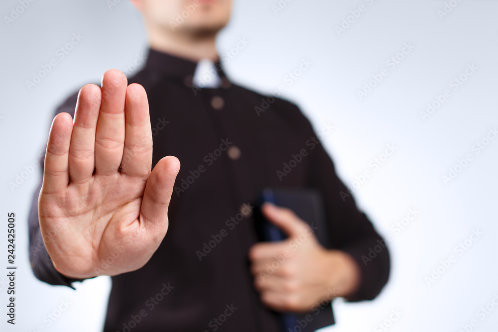 Murais de parede Priest extending his open palm on grey background