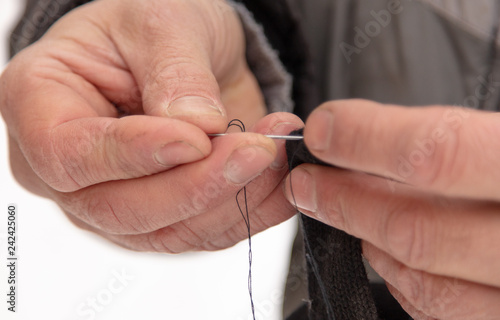A man sews a needle cloth