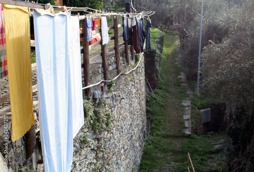 Fotografie Bucato steso ad asciugare con steccato e muro in pietra