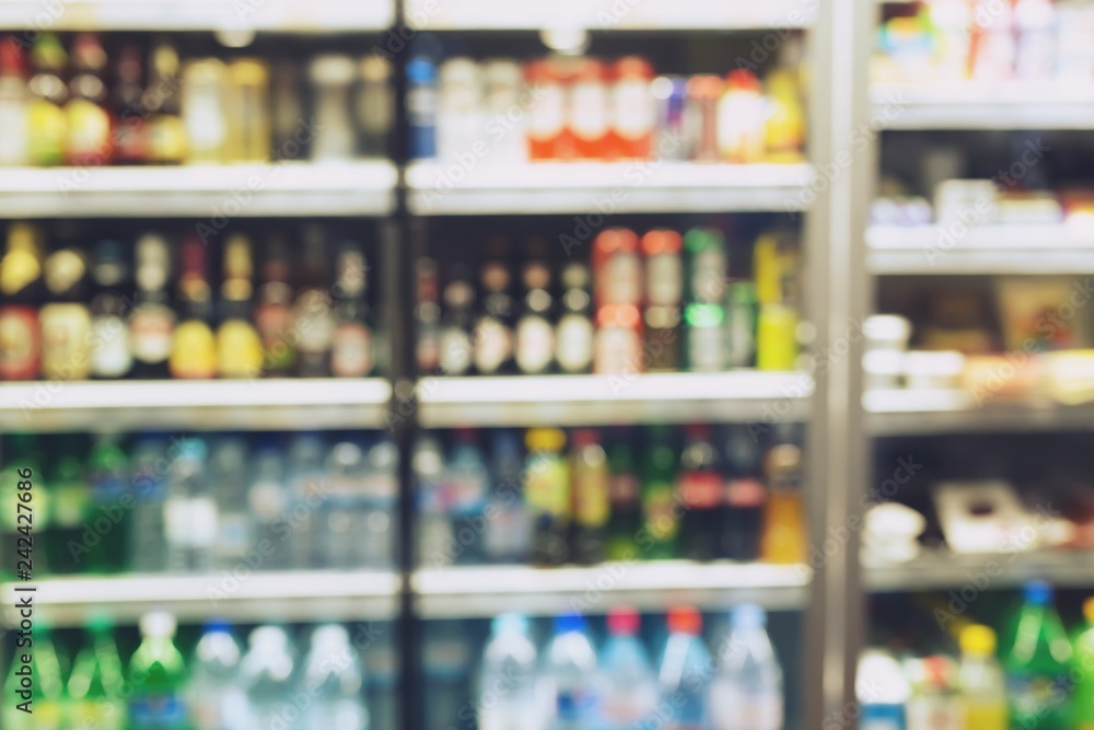 photo blurred  Drink products Beverage soft drink bottles in  supermarket refrigerator Variety of drinks on shelves in convenience store background. blur Leave copy space empty to write text