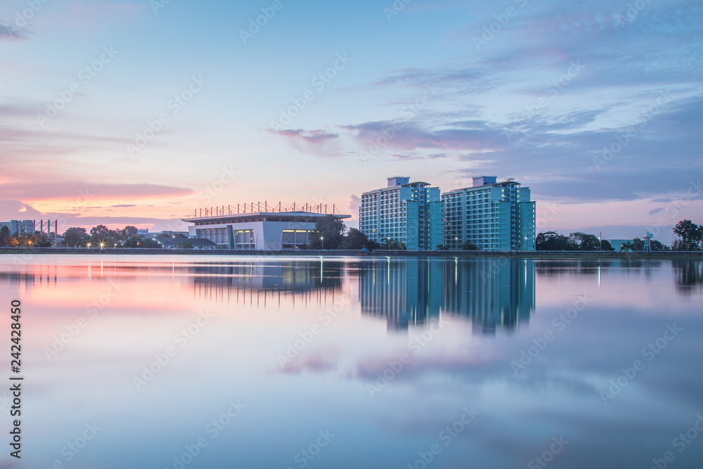 Sunset behind a sport center with reflecting view in water, at Prince of Songkhla University, Thailand 
