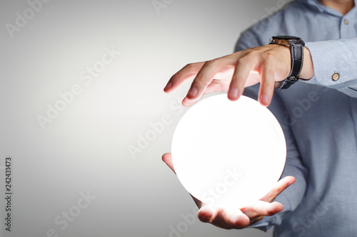 Obraz na płótnie Male hands holding levitating magic ball, isolated on white background