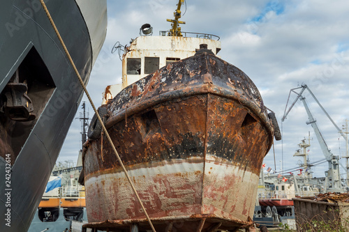 Rusty decommissioned marine ship that was left on the shore.