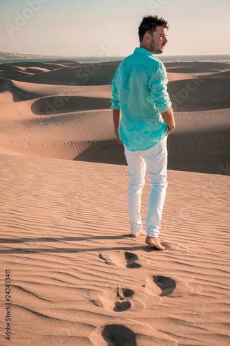 man walking sand dunes of Maspalomas Gran Cania Spain, desert man in desert beach photo