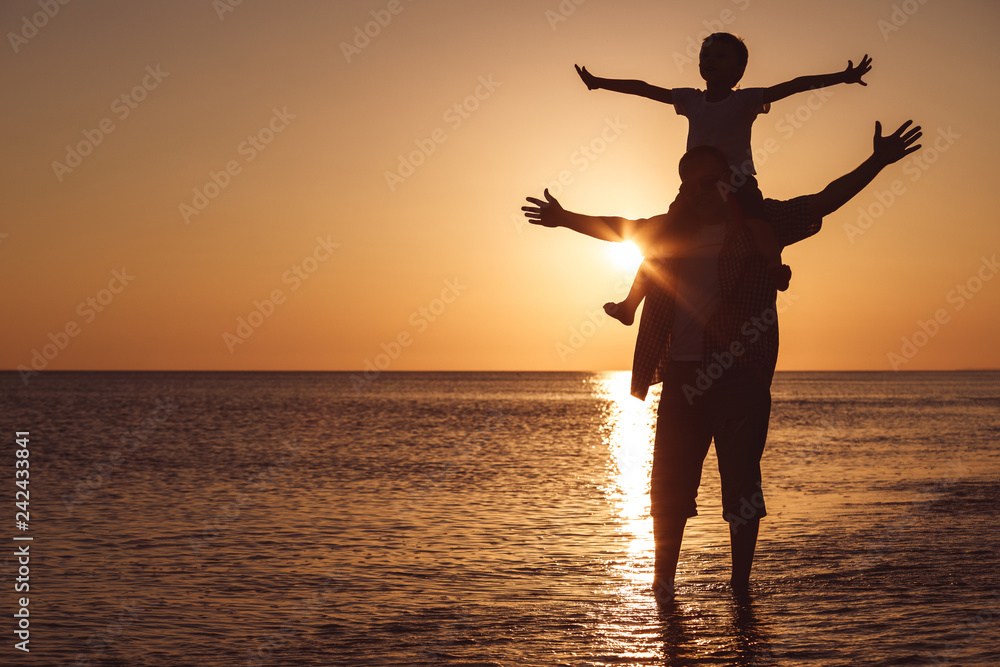 Fototapeta premium Father and son playing on the beach at the sunset time.