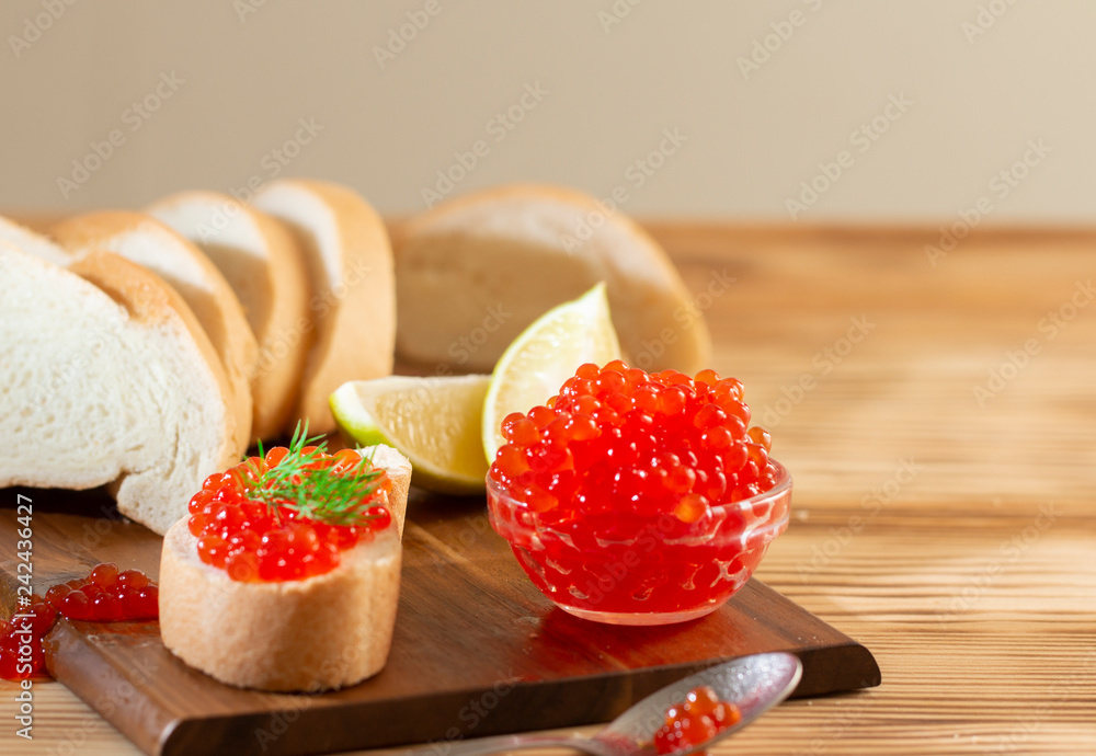 red caviar in glassware on a wooden background in a rustic style with space for text