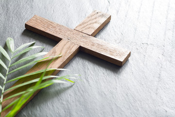 Easter wooden cross on black marble background religion abstract palm sunday concept
