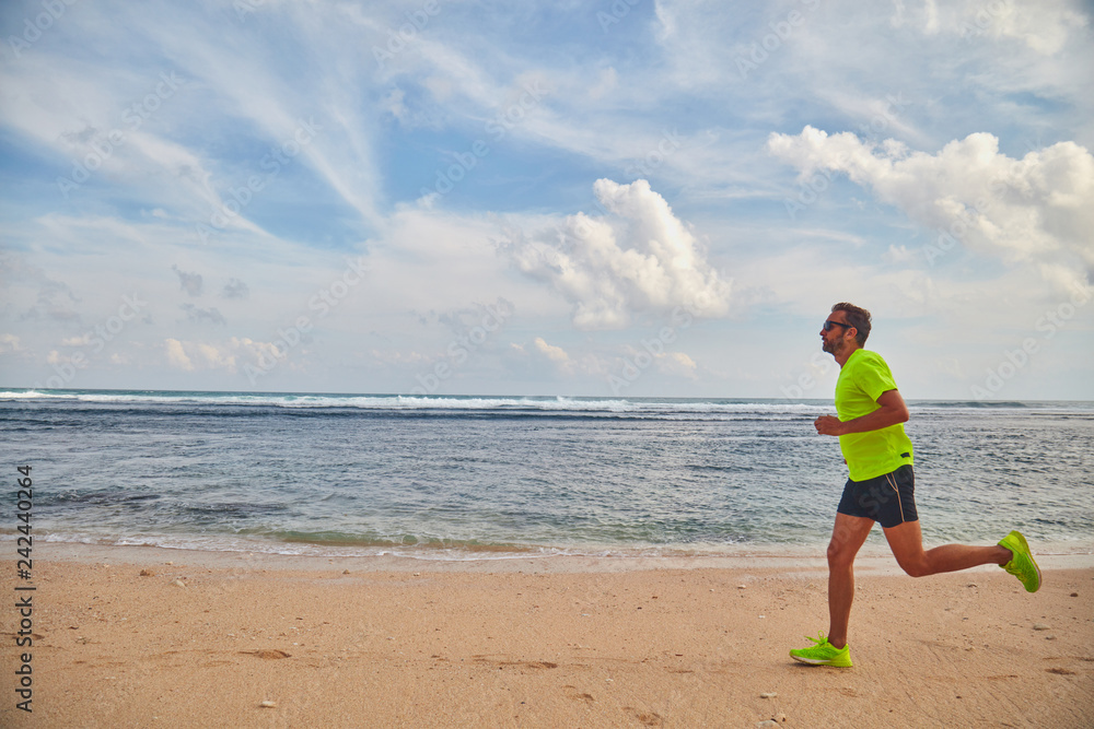 Man running / jogging on a tropical exotic beach. Man running / jogging on a tropical exotic beach.