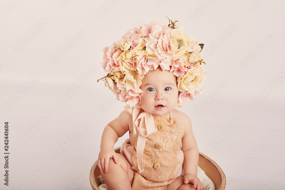 cute baby with flowers on a light background cute baby with flowers on a light background