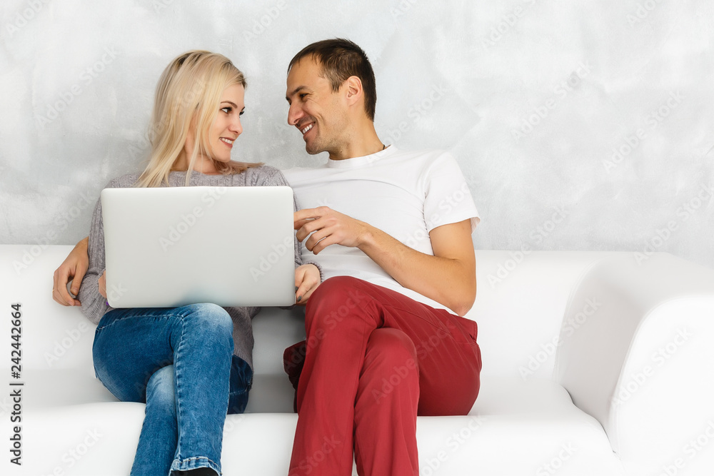 Portrait of happy young couple using laptop isolated on gray background Portrait of happy young couple using laptop isolated on gray background