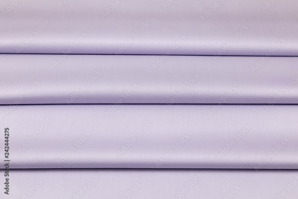 Lilac sateen fabric is laid by equal folds Lilac sateen fabric is laid by equal folds