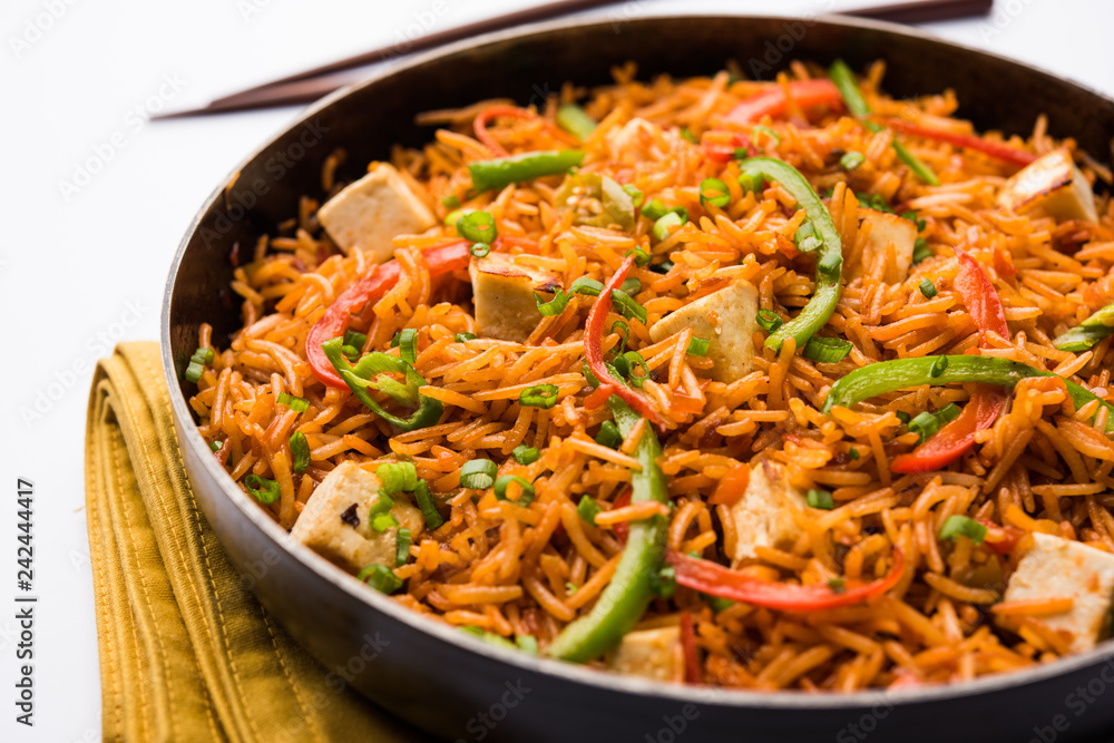 Schezwan paneer fried rice with Szechuan sauce and cottage cheese cubes. served in a bowl or plate or pan. selective focus Schezwan paneer fried rice with Szechuan sauce and cottage cheese cubes. served in a bowl or plate or pan. selective focus