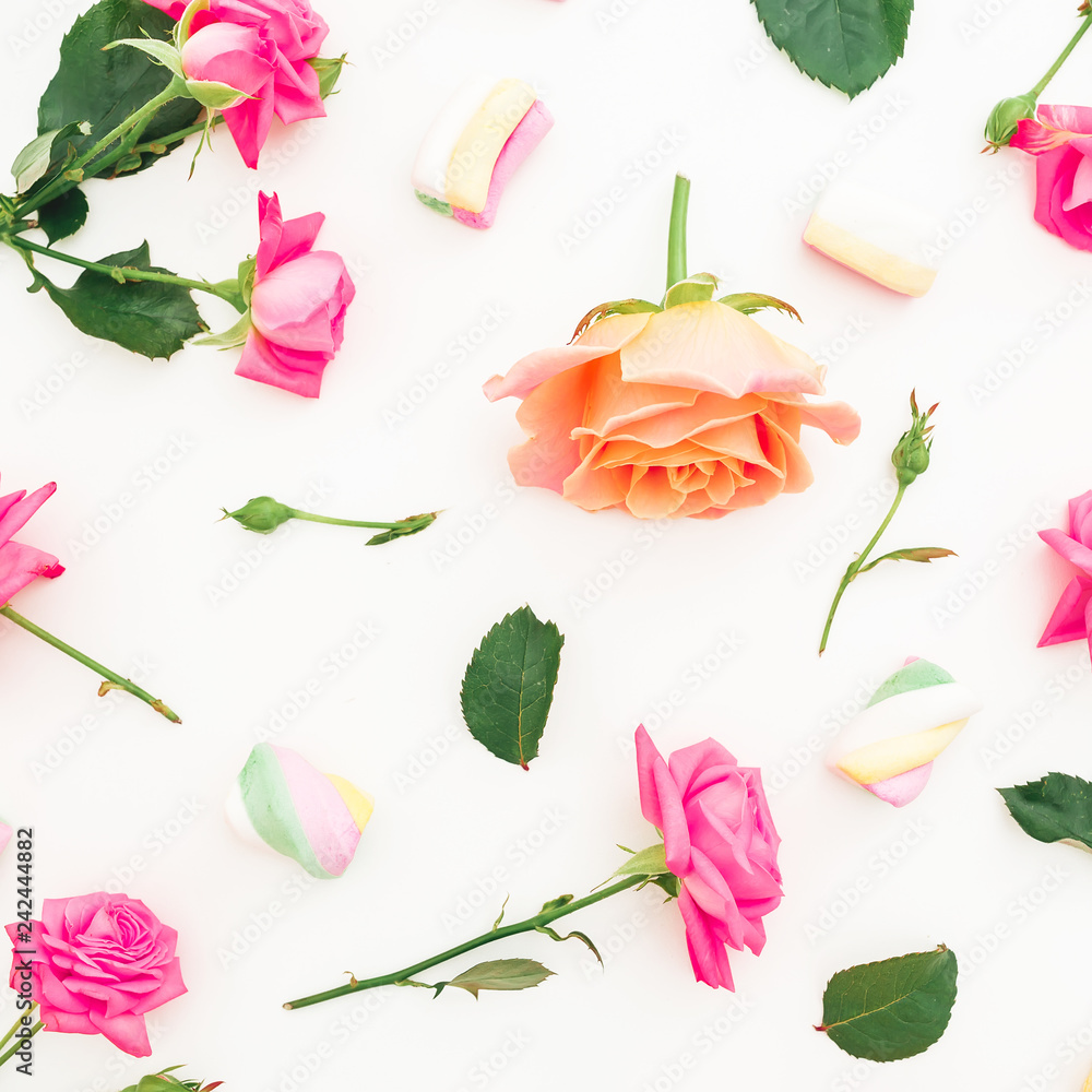 Roses flowers and marshmallow with sugar candy on white background. Flat lay, top view. Roses flowers and marshmallow with sugar candy on white background. Flat lay, top view.