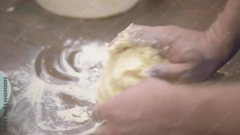 Baker Kneading Dough in Flour on the Kitchen Table. Man Chef Making Cookies at Home. Close up view of Man Hands Preparing Dough for Curd Pancakes. Baker Kneading Dough in Flour on the Kitchen Table. Man Chef Making Cookies at Home. Close up view of Man Hands Preparing Dough for Curd Pancakes.