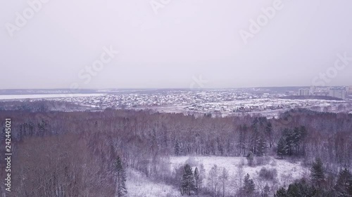 flight in winter on the drone above the forest on the background of the city. Aerial Winter Park Landscape Above Montreal, Canada