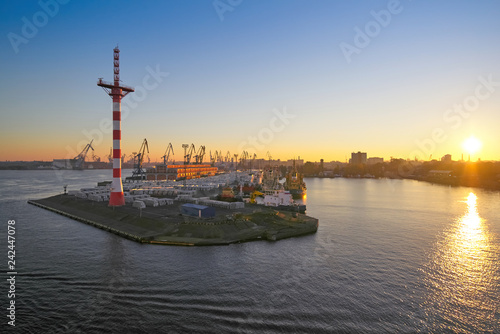 View of the sunset at the port with the mast of navigation equipment and cargo berth of ships, sunrise