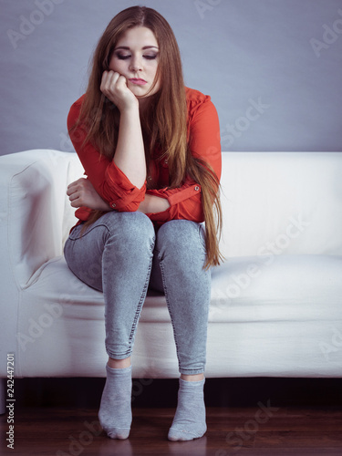 Angry woman sitting on sofa photo