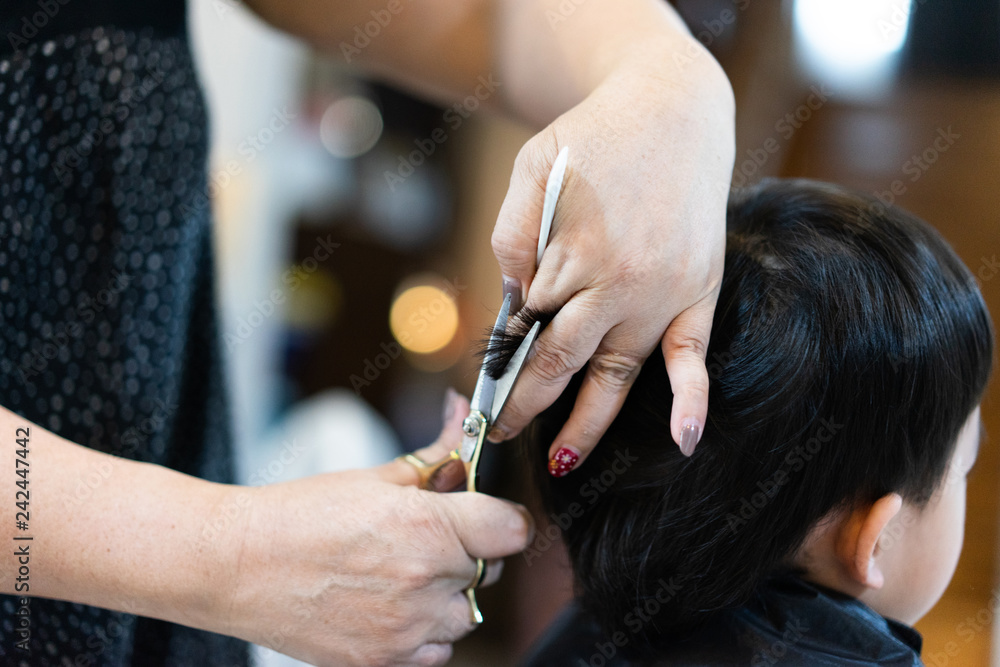 Grandmother is cutting hair of her grandson at home. Grandmother is cutting hair of her grandson at home.