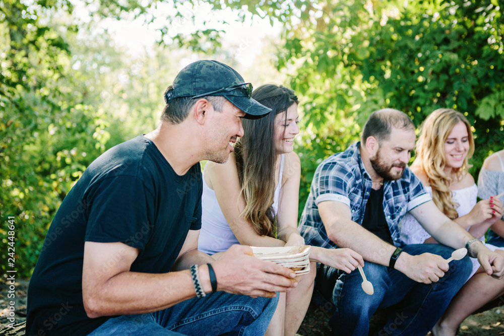 Happy people having a pic-nic. Group of friends making barbecue in the nature. Concept about good and positive Happy people having a pic-nic. Group of friends making barbecue in the nature. Concept about good and positive